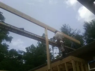 Carpenter setting a ridge beam over a new addition frame — Ice Dam Removal by Roofing Brothers in Roma