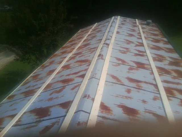 Rusted metal roof panels with new wood purlins before replacement — Storm Damage Roof Repair in Roma by Roofing Brothers