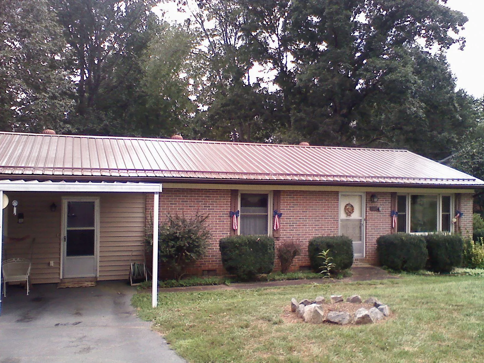 Bronze metal roof and carport on a brick ranch home — Roof Repair work by our crew in Roma